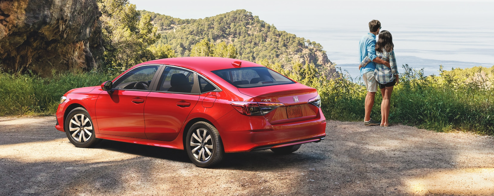 red honda civic with couple standing nearby